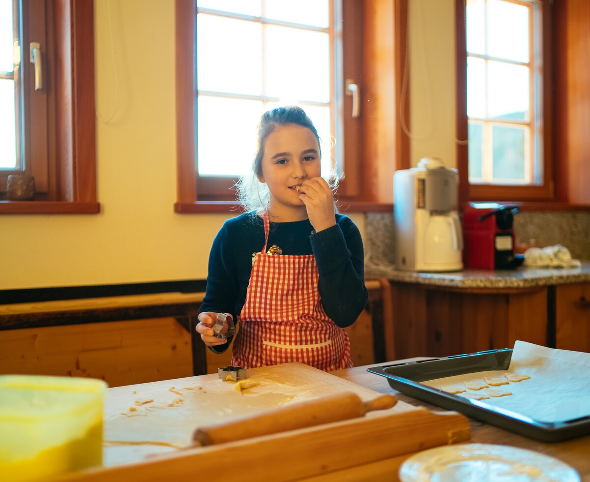 Mädchen beim Kekse backen | © Urlaub am Bauernhof Kärnten / Daniel Gollner Mädchen backt Kekse und kostet den Teig | © Urlaub am Bauernhof Kärnten / Daniel Gollner