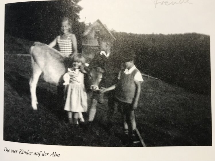 Vier Kinder stehen am Bach, einer reitet auf einem Pferd. Hinter ihnen sind Hügel und Bäume zu sehen. Das Bild hat einen nostalgischen, ländlichen Charakter. | © Urlaub am Bauernhof / Schell