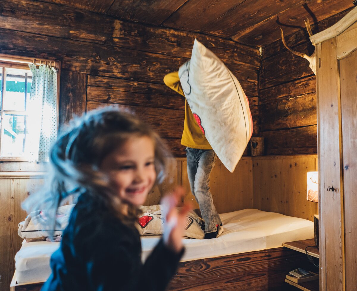 Polsterschlacht in der Almhütte | © Urlaub am Bauernhof Salzburg / Daniel Gollner Zwei Kinder spielen in der Almhütte | © Urlaub am Bauernhof Salzburg / Daniel Gollner