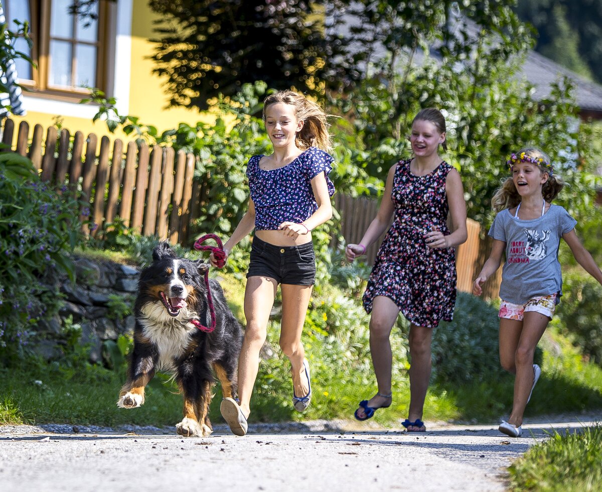 Kinder laufen mit Hund | © Urlaub am Bauernhof Kärnten / Tom Lamm Kinder laufen mit Hund an der Leine über die Straße | © Urlaub am Bauernhof Kärnten / Tom Lamm