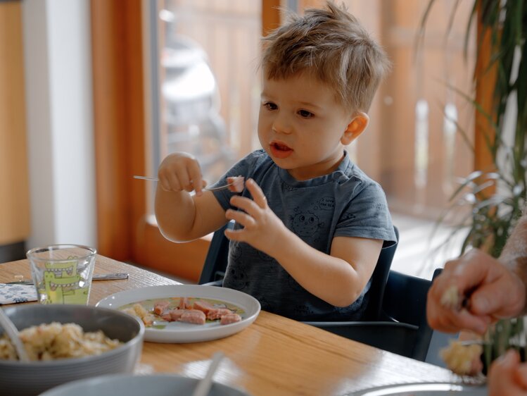 Sohn ist Selchwürste genussvoll | © Daniel Gollner/ Urlaub am Bauernhof Kärnten