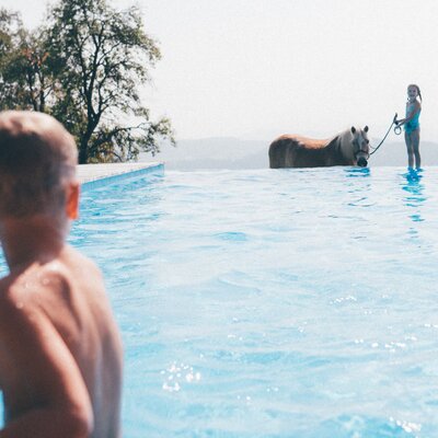 Kind im Pool und Mädchen mit Pony | © Urlaub am Bauernhof Kärnten / Daniel Gollner