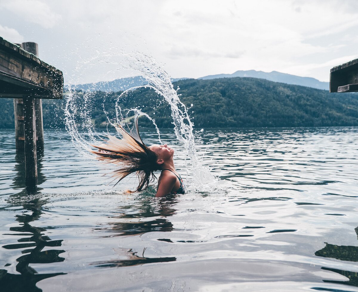 Mädchen im See | © Urlaub am Bauernhof Kärnten/ Daniel Gollner Mädchen im See spritzt das Wasser mit den Haaren | © Urlaub am Bauernhof Kärnten/ Daniel Gollner