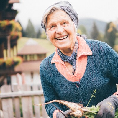 Frau mit Karotten in der Hand | © Urlaub am Bauernhof Kärnten / Daniel Gollner
