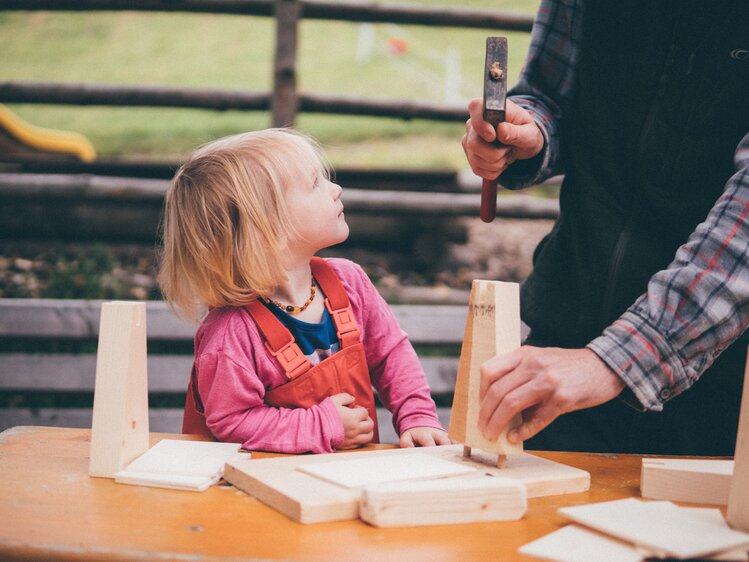Mädchen bastelt am Tisch mit Holz | © Urlaub am Bauernhof Kärnten / Daniel Gollner