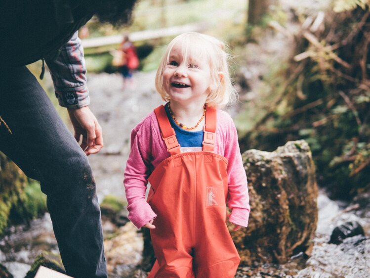 Mädchen steht im Bach und lächelt | © Urlaub am Bauernhof Kärnten / Daniel Gollner