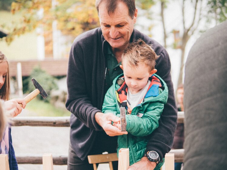 Mann und Kind basteln mit dem Hammer | © Urlaub am Bauernhof Kärnten/Daniel Gollner