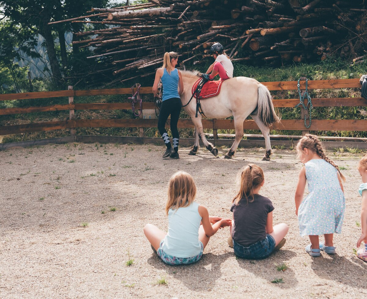 Frau führt Pferd | © Urlaub am Bauernhof Kärnten / Daniel Gollner Frau führt Pferd im Viereck und Kinder schauen zu | © Urlaub am Bauernhof Kärnten / Daniel Gollner