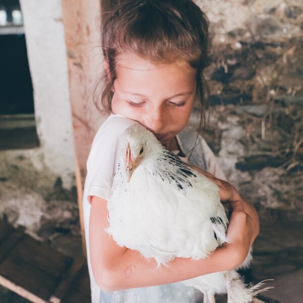 Mädchen hält das Huhn im Arm | © Urlaub am Bauernhof Kärnten / Daniel Gollner