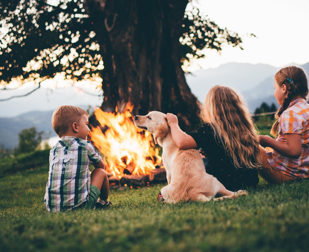 Kinder bei Lagerfeuer | © Urlaub am Bauernhof Kärnten/ Daniel Gollner Kinder sitzen mit dem Hund beim Lagerfeuer | © Urlaub am Bauernhof Kärnten/ Daniel Gollner