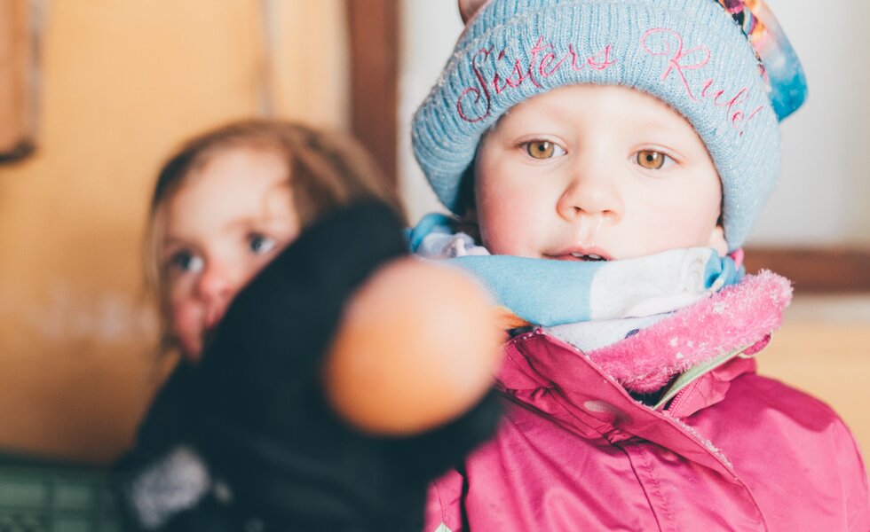 Mädchen hält das Ei in der Hand | © Urlaub am Bauernhof Kärnten / Daniel Gollner