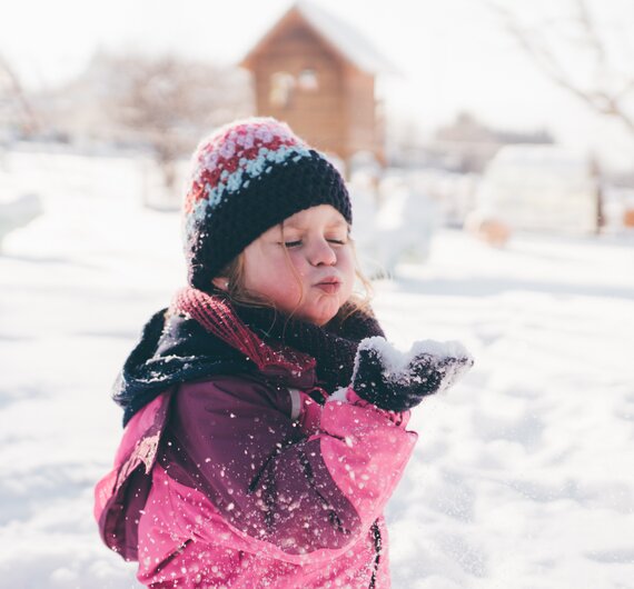 Mädchen pustet in den Schnee | © Urlaub am Bauernhof Kärnten/ Daniel Gollner
