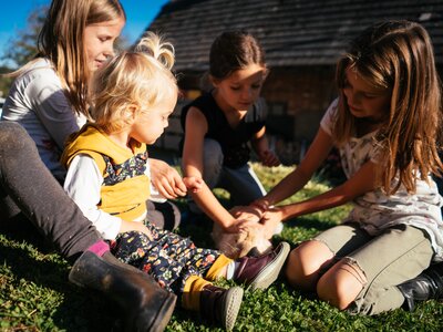 Kinder sitzen auf der Wiese und streicheln den Hasen | © Urlaub am Bauernhof Kärnten / Daniel Gollner
