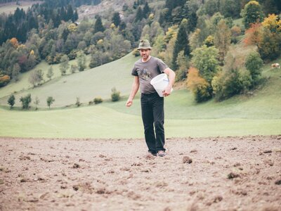 Mann sät am Feld | © Urlaub am Bauernhof Kärnten / Daniel Gollner