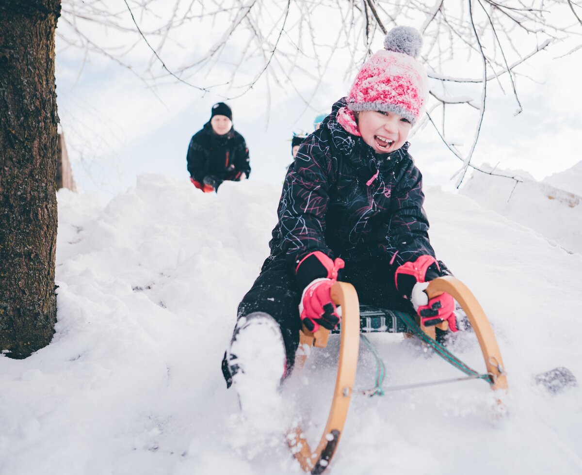 Kind mit dem Schlitten | © Urlaub am Bauernhof Kärnten/ Daniel Gollner Kind sitzt auf dem Schlitten im Schnee | © Urlaub am Bauernhof Kärnten/ Daniel Gollner