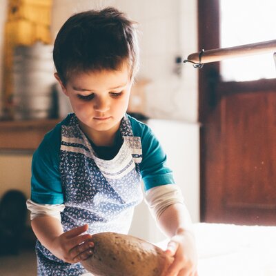 Bub nimmt das Brot von der Arbeitsplatte | © Urlaub am Bauernhof Kärnten/ Daniel Gollner