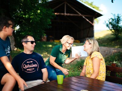 Familie sitzt am Tisch | © Urlaub am Bauernhof Kärnten / Daniel Gollner Familie sitzt draußen am Tisch | © Urlaub am Bauernhof Kärnten / Daniel Gollner