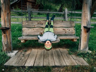 Bub auf der Schaukel | © Urlaub am Bauernhof Kärnten/ Daniel Gollner Bub liegt kopfüber auf der Schaukel | © Urlaub am Bauernhof Kärnten/ Daniel Gollner