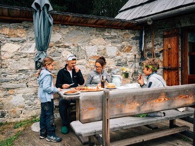 Familie isst am Tisch | © Urlaub am Bauernhof Kärnten / Daniel Gollner Familie isst am Tisch vor der Hütte | © Urlaub am Bauernhof Kärnten / Daniel Gollner