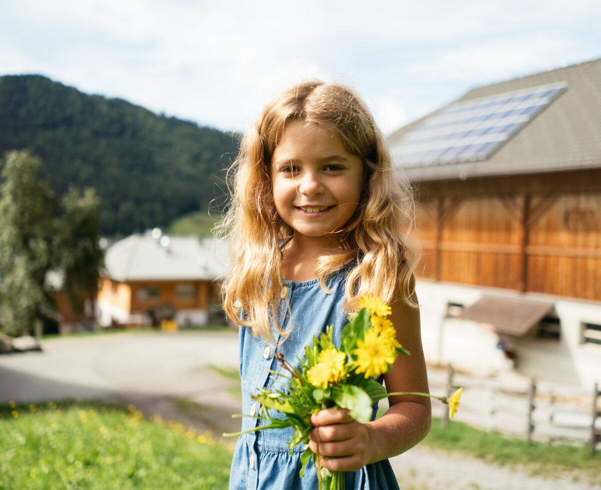 Mädchen hält gelben Blumenstrauß beim Neusacher Moser | © Urlaub am Bauernhof / Daniel Gollner