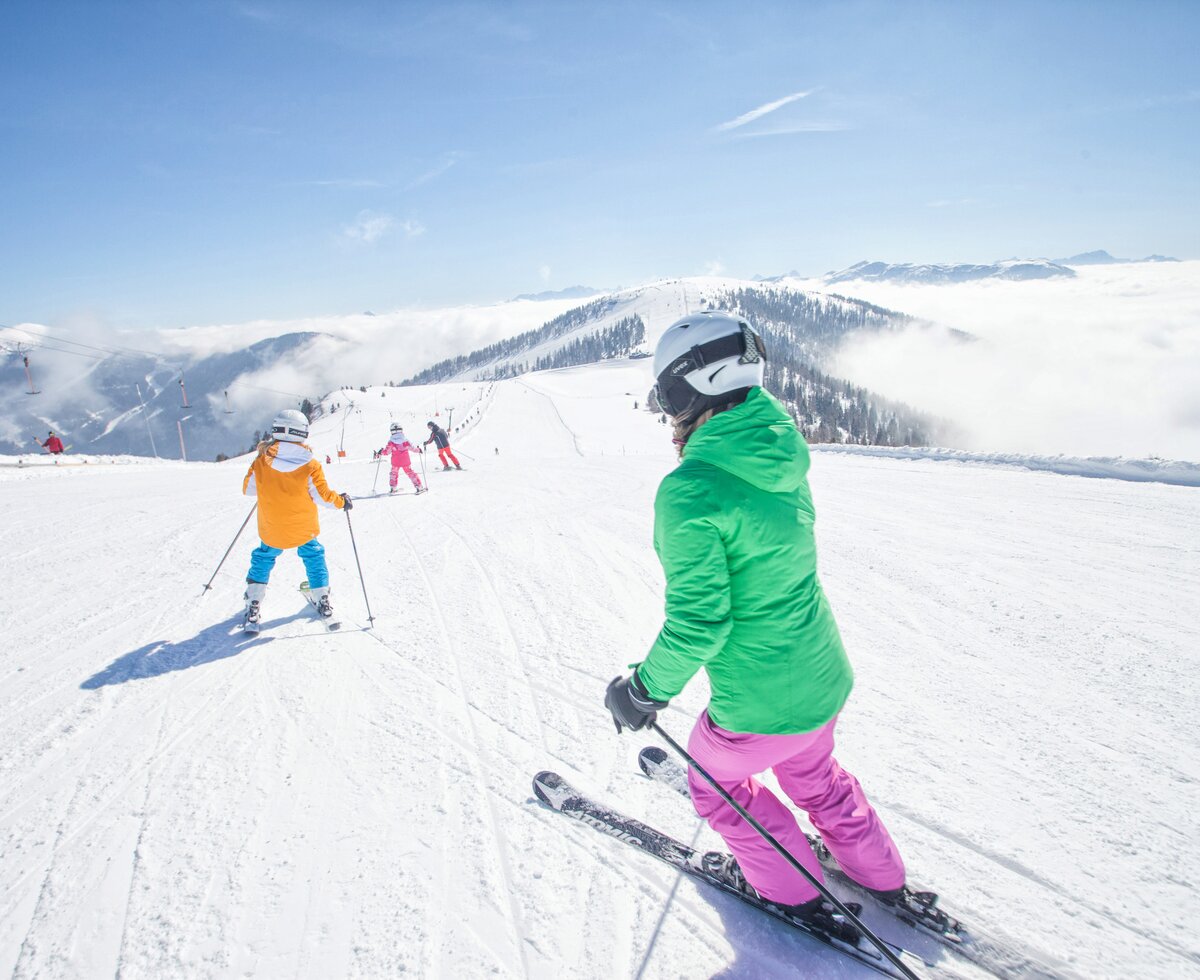 Familienskifahren in Bad Kleinkirchheim | © Mathias Prägant / BRM Bad Kleinkirchheim Region Marketing GmbH Vierköpfige Familie fährt Ski auf der Piste in Bad Kleinkirchheim | © Mathias Prägant / BRM Bad Kleinkirchheim Region Marketing GmbH