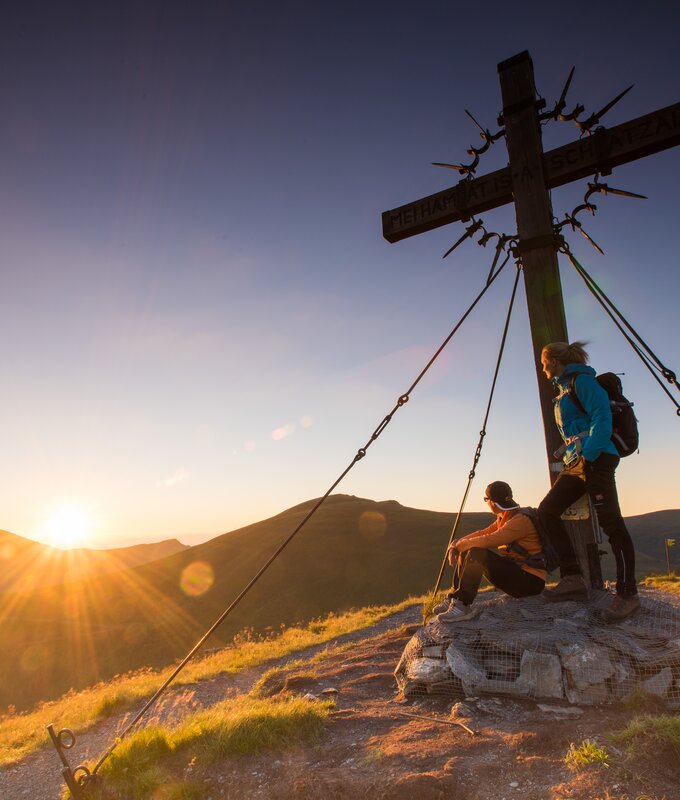 Zwei Personen stehen beim Gipfelkreuz zum Sonnenaufgang | © Franz Gerdl / Kärnten Werbung GmbH 
