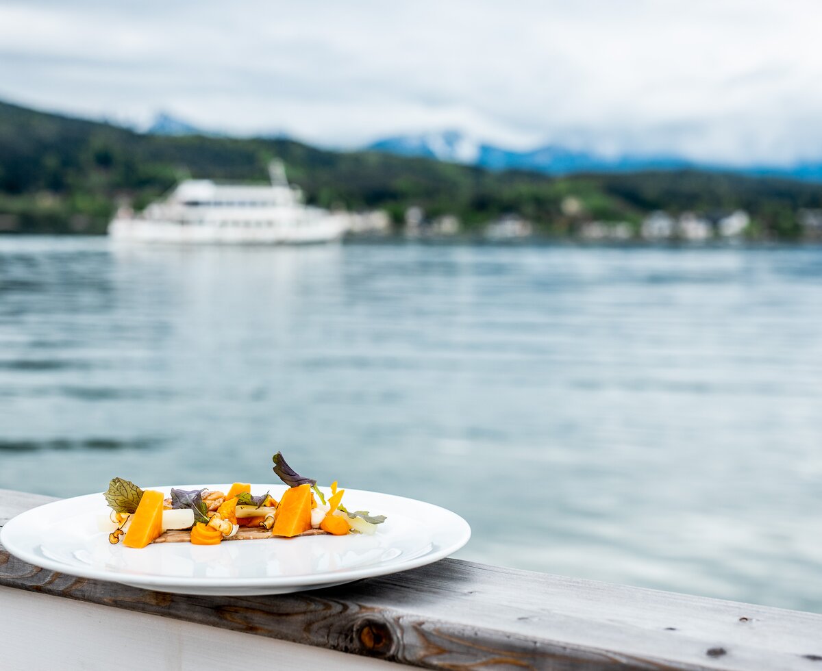 SeeEssSpiele am Wörthersee | © Daniel Waschnig / Wörthersee Tourismus GmbH Teller mit Essbaren mit See im Hintergrund | © Daniel Waschnig / Wörthersee Tourismus GmbH