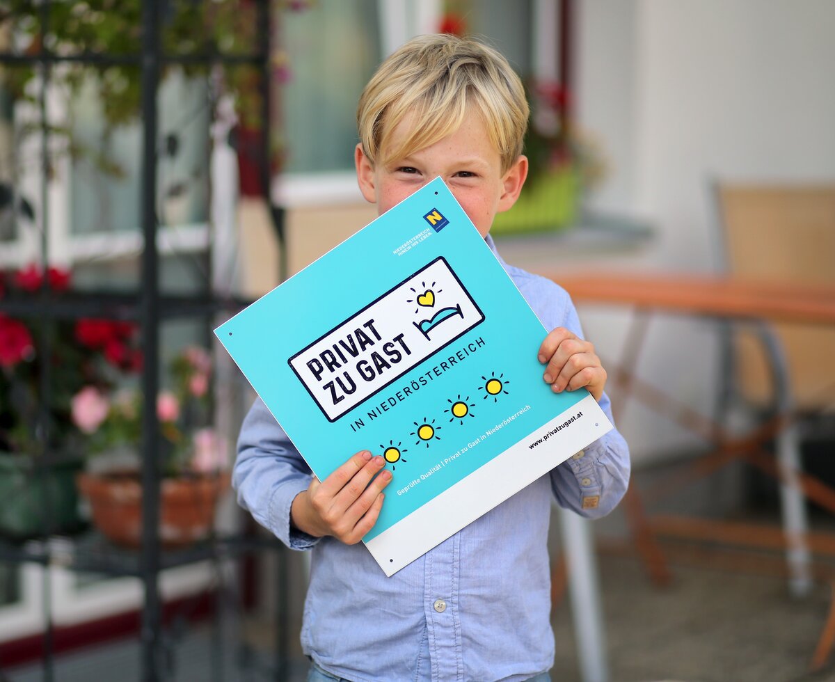 Bub hält Privat zu Gast Tafel in der Hand | © Privat zu Gast in Niederösterreich / weinfranz.at Bub hält Privat zu Gast Tafel in der Hand | © Privat zu Gast in Niederösterreich / weinfranz.at