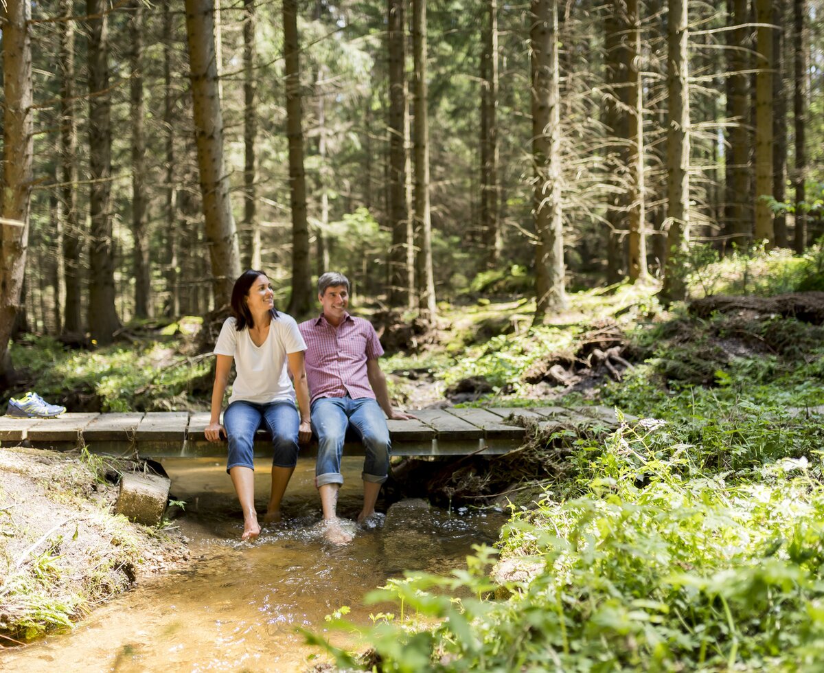 Couple sitting on bridge in Waldviertel region | © Waldviertel Tourismus / Robert Herbst Couple sitting on bridge with feet hanging in stream | © Waldviertel Tourismus / Robert Herbst