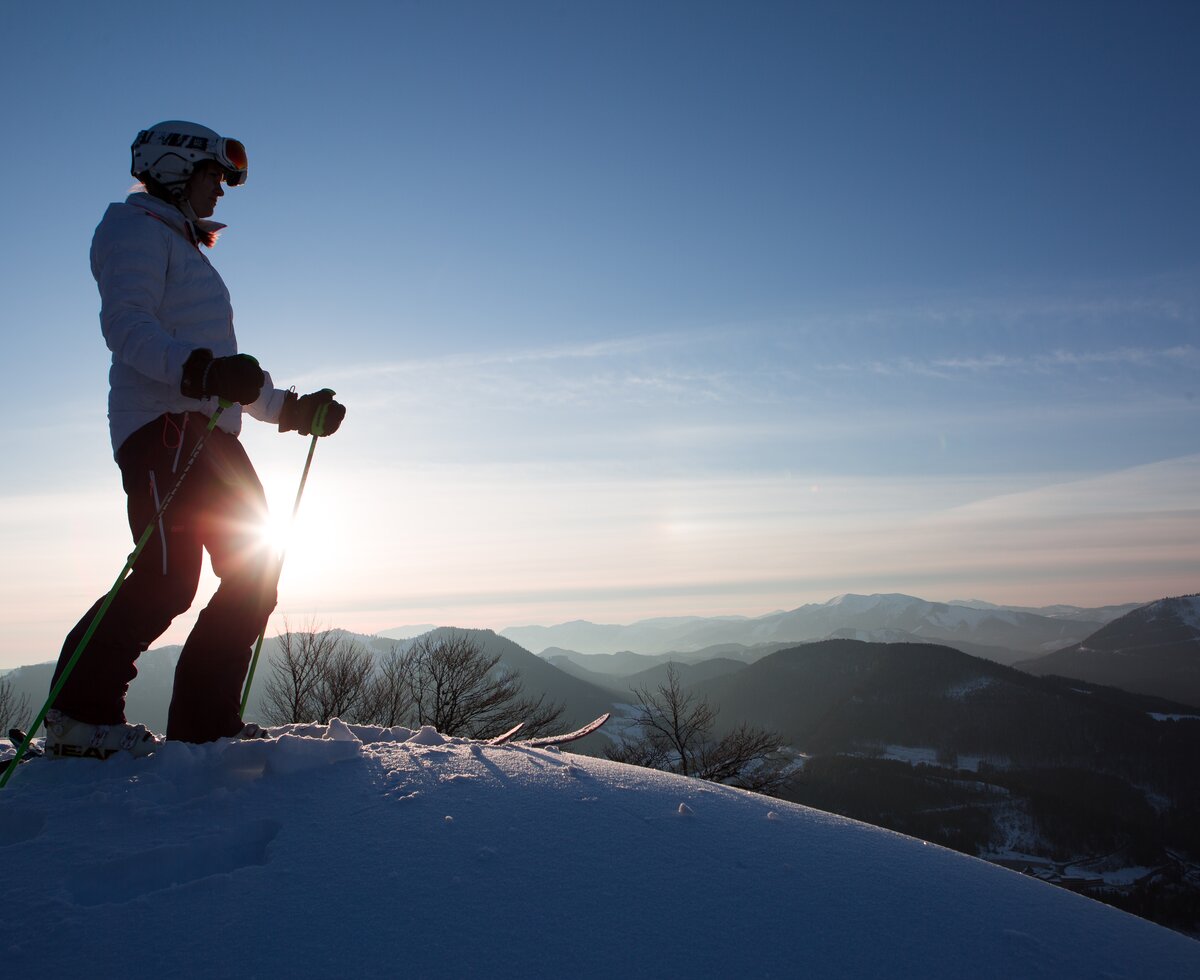 Skifahrerin auf Gipfel | © Niederösterreich Werbung / schwarz-koenig.at Skifahrerin steht auf Gipfel bei Sonnenaufgang | © Niederösterreich Werbung / schwarz-koenig.at