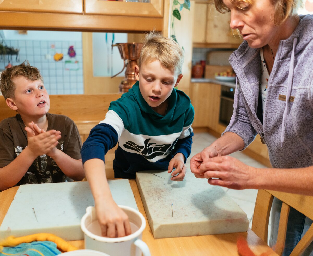 Bäuerin mit zwei Buben am Filzen | © Urlaub am Bauernhof Oberösterreich / Daniel Gollner
