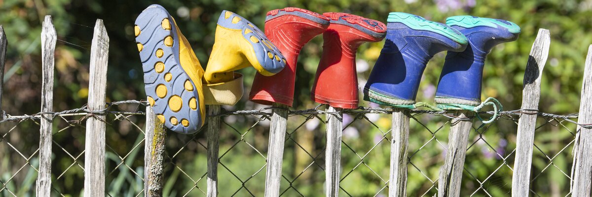 Bunte Gummistiefel hängen über dem Zaun | © Urlaub am Bauernhof Oberösterreich / puremotions photography