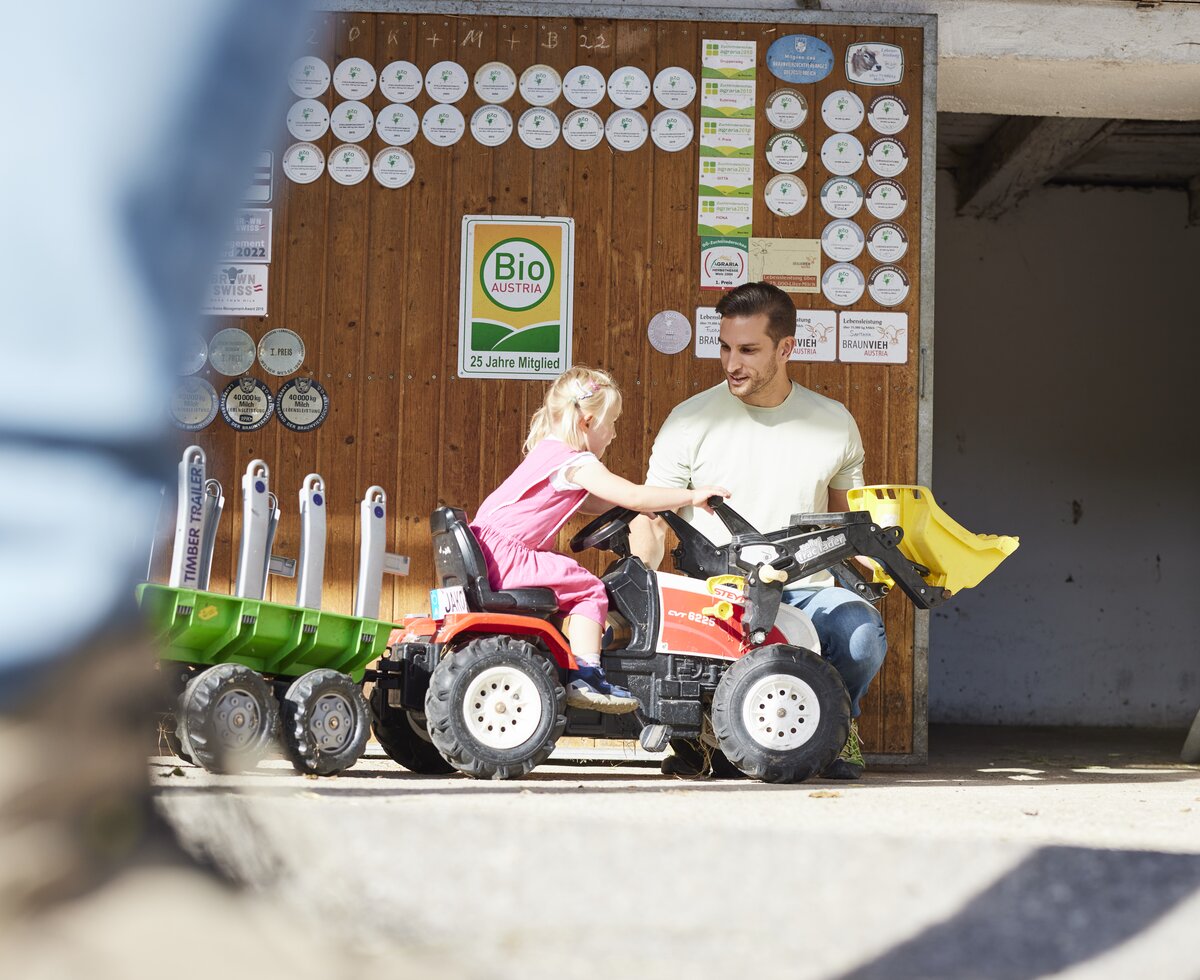 Trettraktor fahren | © Urlaub am Bauernhof Oberösterreich / Alexander Kaiser Mädchen fährt mit Trettraktor | © Urlaub am Bauernhof Oberösterreich / Alexander Kaiser