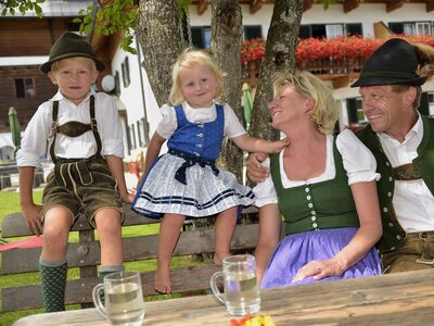 Familie in Tracht sitzt auf der Terrasse | © Urlaub am Bauernhof Oberösterreich / Ralph Fischbacher