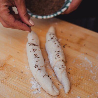 Salzstangerl mit Salz und Kümmel bestreuen | © Footprints Fotografie // cookingCatrin