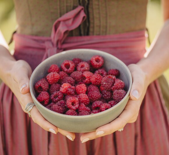 Frau mit Schale Himbeeren in der Hand | © Urlaub am Bauernhof Oberösterreich / Footprints Fotografie - cookingCatrin