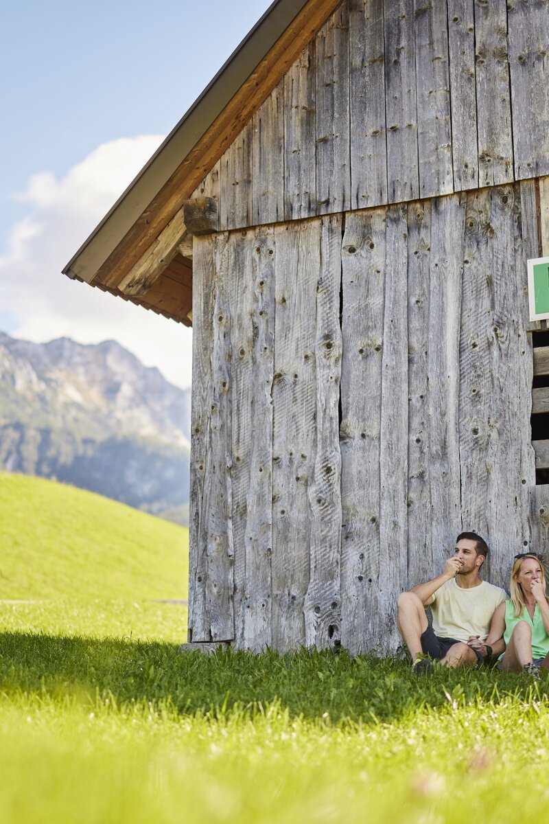 Paar lehnt an einer Holzhütte von Urlaub am Bauernhof | © Urlaub am Bauernhof Oberösterreich / Alexander Kaiser
