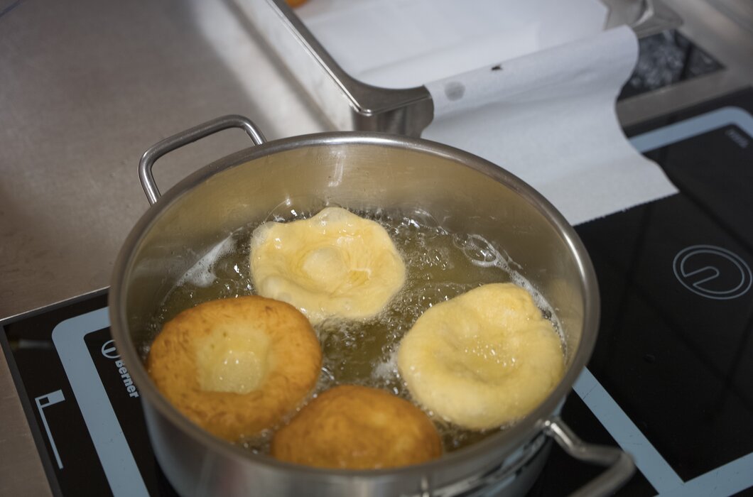 Edelstahlpfanne mit gebratenen Bällchen in heißem Fett, die köstlich aussehen. | © Urlaub am Bauernhof / Daniel Gollner