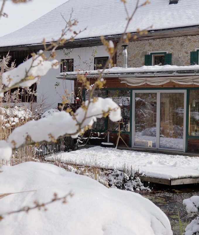 Winterliches Berghaus mit Schnee bedeckter Umgebung, gepflegter Terrasse und holzverzierten Fassade. Traditionelle alpine Architektur umgeben von verschneiter Landschaft. | © Urlaub am Bauernhof / Daniel Gollner