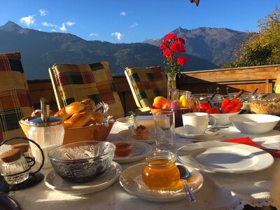 Frühstück im Freien | © Antje Zimmermann / Urlaub am Bauernhof Frühstückstisch im Freien mit Bergen im Hintergrund | © Antje Zimmermann / Urlaub am Bauernhof