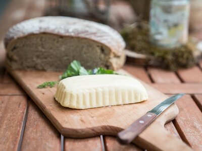 Bauernbrot und Almbutter | © Urlaub am Bauernhof im SalzburgerLand / Matthias Gruber Bauernbrot und Almbutter liegen auf einem Holzbrett. | © Urlaub am Bauernhof im SalzburgerLand / Matthias Gruber