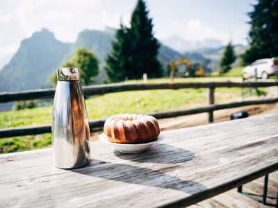 Kaffeejause auf der Alm | © Urlaub am Bauernhof im SalzburgerLand / Daniel Gollner Ein Guglhupf und eine Thermoskanne mit Kaffee stehen auf dem Tisch vor der Almhütte. | © Urlaub am Bauernhof im SalzburgerLand / Daniel Gollner