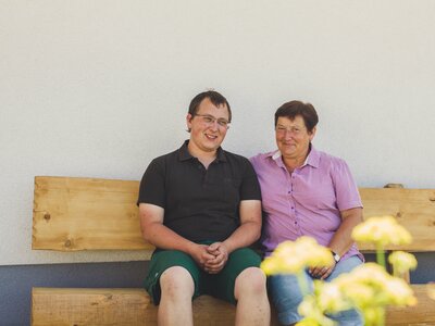 Karin and Matthias Pöllmann are sitting on the house bench. | © Farmholidays in SalzburgerLand / Matthias Gruber Karin and Matthias Pöllmann are sitting on the house bench. | © Farmholidays in SalzburgerLand / Matthias Gruber