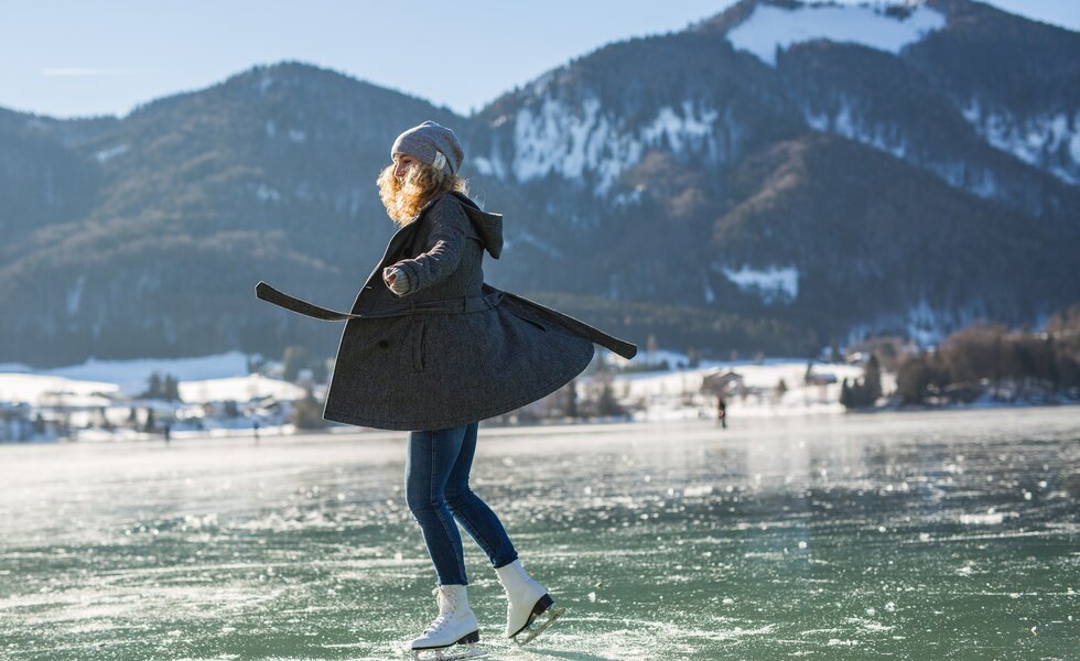 Eine junge Frau fährt auf Schlittschuhen über den Fuschlsee im SalzburgerLand. | © SLT / Michael Groessinger