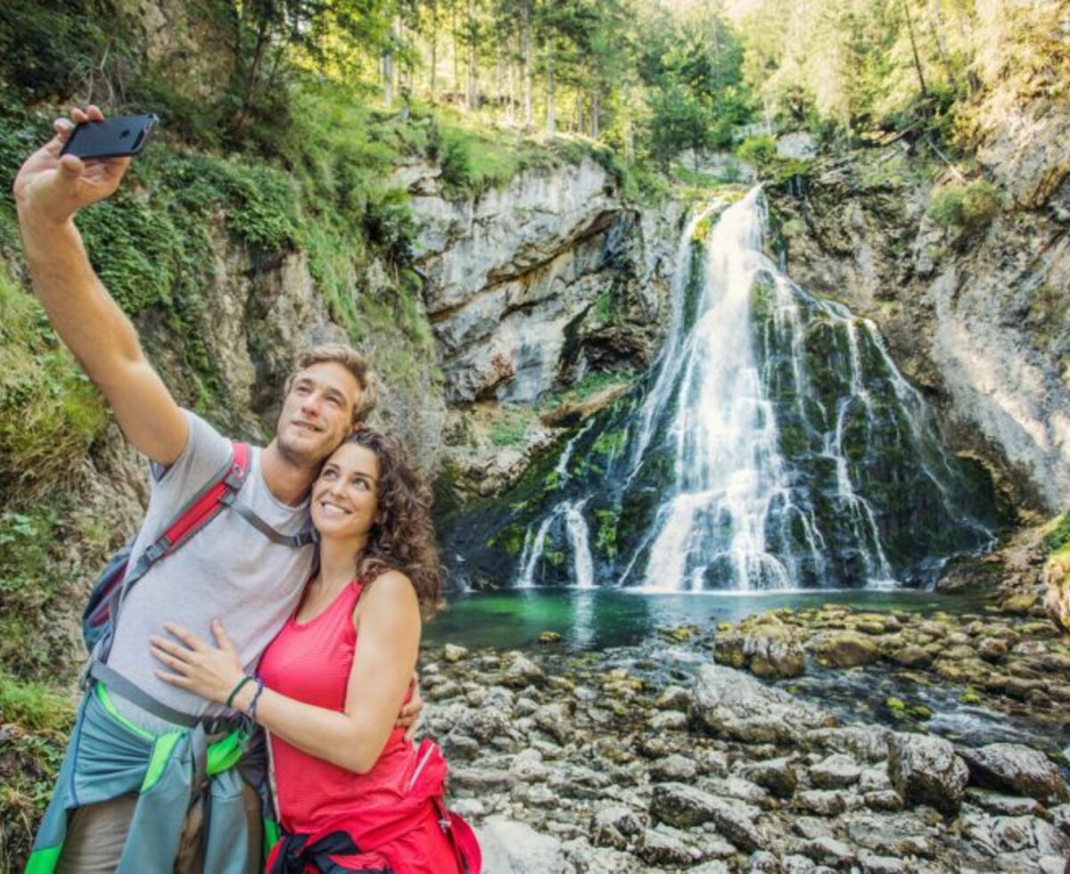 Gollinger Wasserfall, Golling, Tennengau, Salzburger Land | © Salzburger Land Tourismus Gollinger Wasserfall mit Personen im Vordergrund, dass ein Selfie macht, Golling, Tennengau, Salzburger Land | © Salzburger Land Tourismus