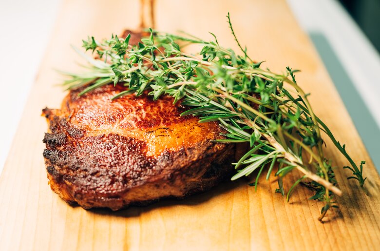 Fleisch mit Kräutern auf Holz, Hochsteiermark, Steiermark | © Urlaub am Bauernhof / Daniel Gollner fertig gebratenes Fleisch mit Kräutern auf Holz liegend, Hochsteiermark, Steiermark | © Urlaub am Bauernhof / Daniel Gollner