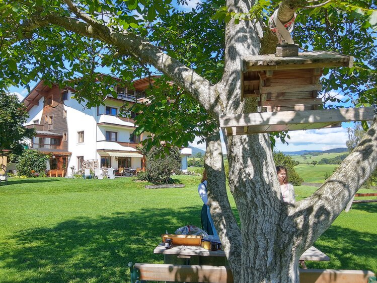 Vogerlhäuserl am Baum mit Wohnhaus im Hintergrund, Almenlandhof, Steiermark | © Urlaub am Bauernhof Steiermark / Evelyn Götz
