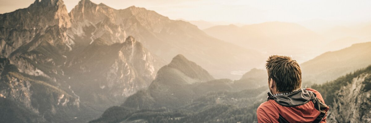 Ein Wanderer macht eine Rast und blickt auf die Berge | © TRV Gesäuse  / Stefan Leitner
