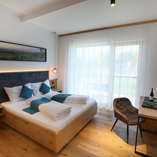 Doppelzimmer im Hof mit Doppelbett, Schreibtisch, Fernseher, Balkonzugang und Poolblick.