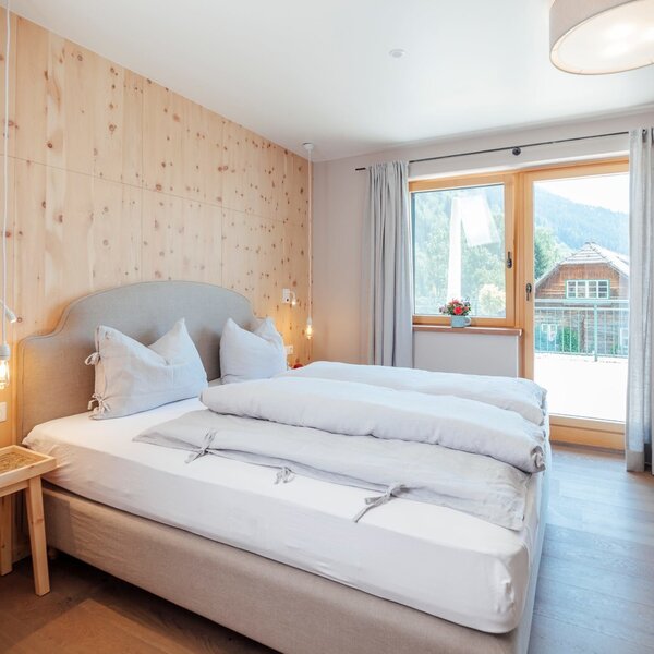 Doppelzimmer auf dem Bauernhof mit Zirbenholzvertäfelung, Balkon und Bergblick.